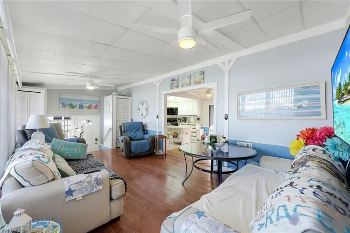 Living room featuring ceiling fan, plenty of natural light, and hardwood / wood-style floors