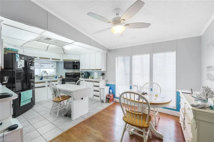 Kitchen featuring a healthy amount of sunlight, black appliances, light hardwood / wood-style floors, and a center island