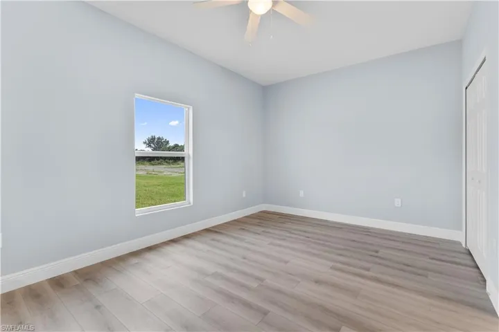 Unfurnished bedroom with a closet, ceiling fan, and light wood-style floors