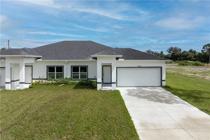 Prairie-style home with an attached garage, a front lawn, roof with shingles, and stucco siding