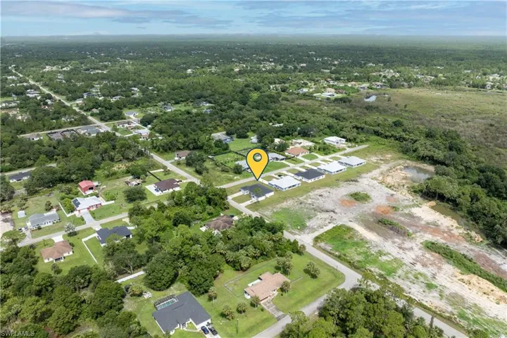 Aerial overview of property's location featuring nearby suburban area and a heavily wooded area