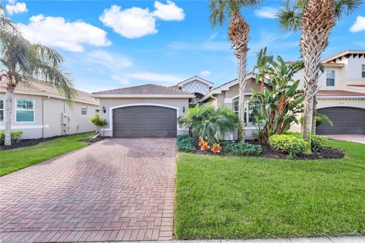 Front of home with brick paver driveway.