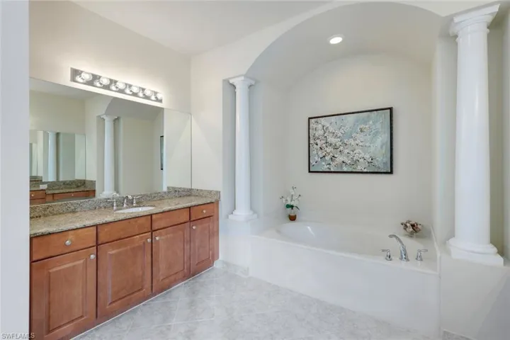 Master bathroom with his & her granite countertop vanities, shower (not shown), tub and W/C (not shown).