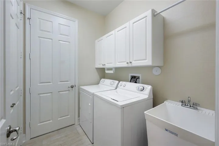 Laundry room with built-in cabinets and laundry tub.