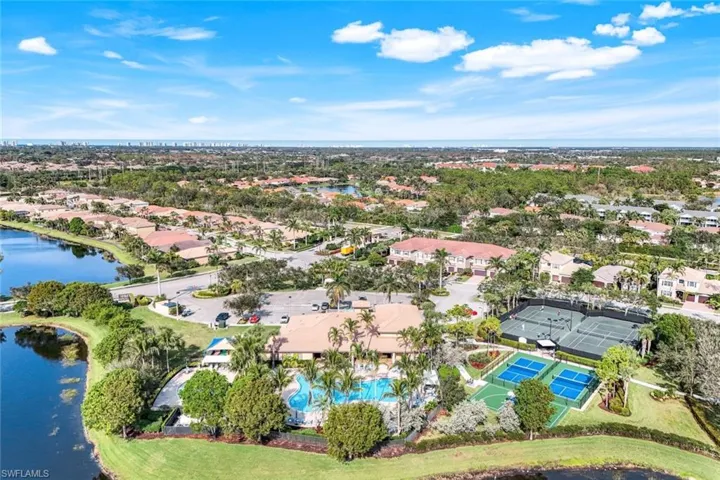 Drone view of clubhouse, resort style pool, pickball courts, basketball court and tennis courts.