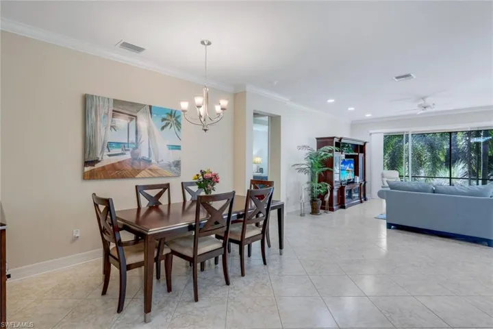 Dining room facing the family room and outdoor lanai access via the sliding glass doors.