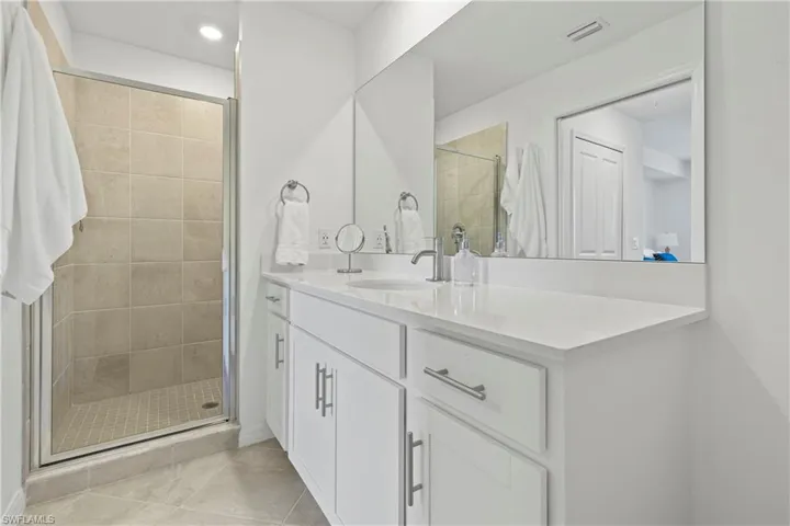 Full bathroom featuring vanity, a shower stall, light tile patterned floors, and recessed lighting