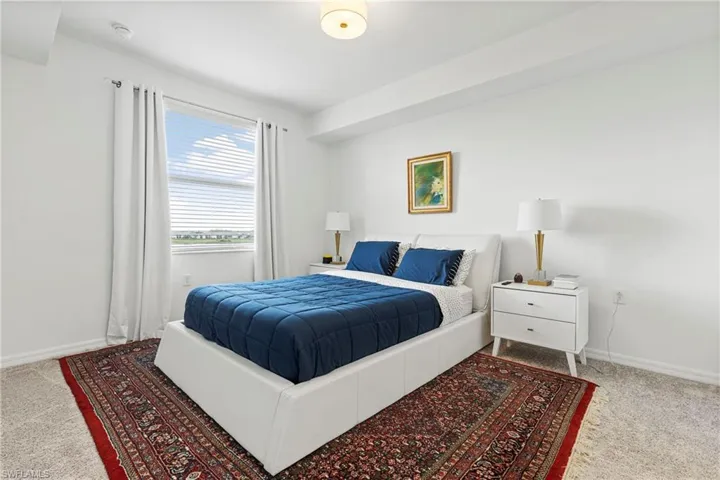Bedroom featuring light carpet and baseboards