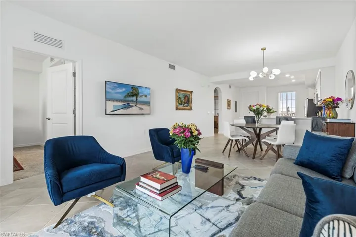 Living area featuring arched walkways and tile patterned floors