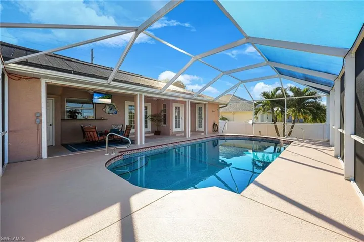 View of pool featuring ceiling fan, a patio area, and glass enclosure