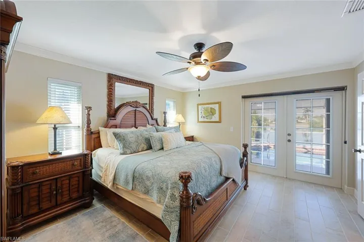 Bedroom featuring french doors, access to outside, multiple windows, and ceiling fan