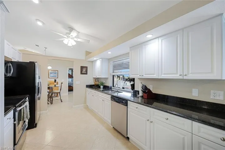 Kitchen with appliances with stainless steel finishes and white cabinetry
