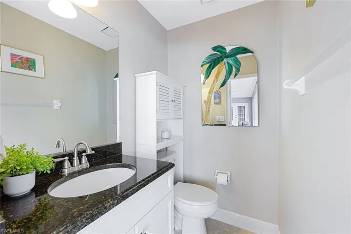 Bathroom featuring tile patterned floors, vanity, and toilet
