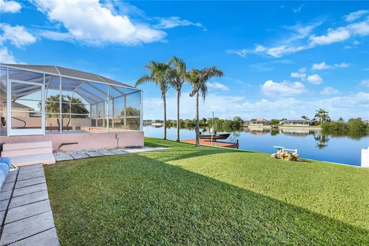 View of yard featuring a lanai, a dock, and a water view