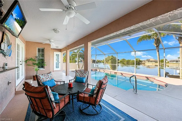 View of patio / terrace with a water view, glass enclosure, and ceiling fan