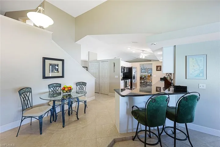 Kitchen featuring pendant lighting, white cabinets, vaulted ceiling, ceiling fan, and kitchen peninsula