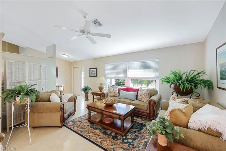 Living room featuring ceiling fan and vaulted ceiling