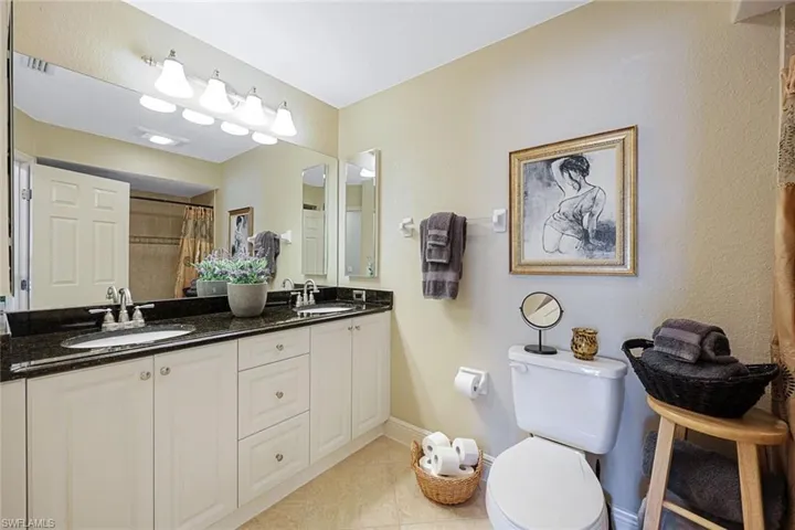 Bathroom with tile patterned flooring, vanity, toilet, and walk in shower
