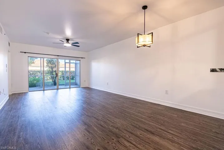 Empty room featuring dark wood finished floors and a ceiling fan