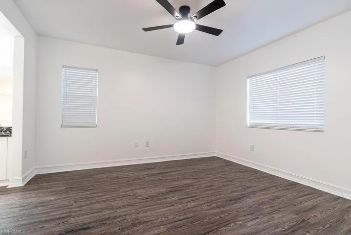 Empty room featuring dark wood finished floors and ceiling fan