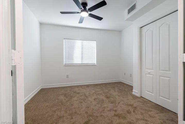 Unfurnished bedroom featuring carpet flooring, a closet, and ceiling fan