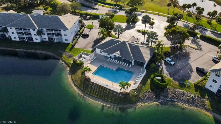 Drone / aerial view of a nearby body of water and a pool