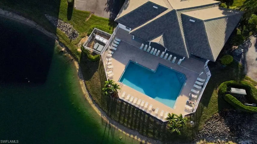 View of subject property with a pool area and a large body of water