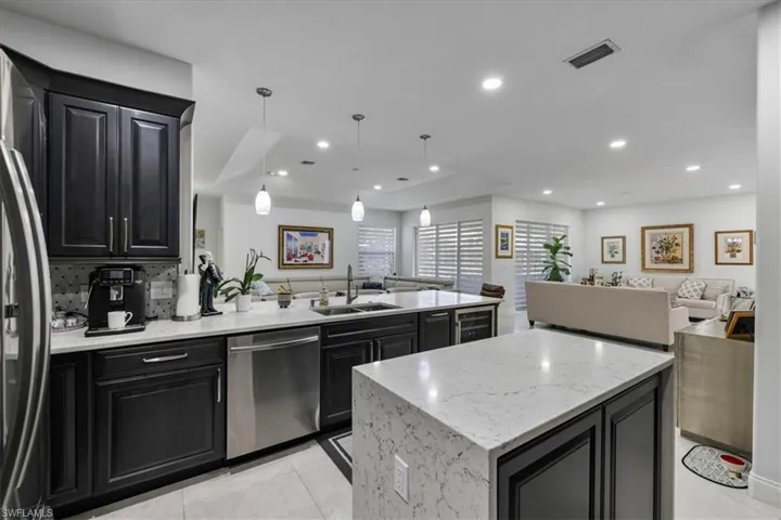 Kitchen with dark cabinets, open floor plan, a peninsula, appliances with stainless steel finishes, and recessed lighting