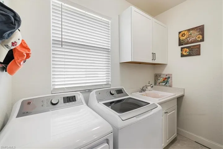 Washroom with cabinet space and washing machine and dryer