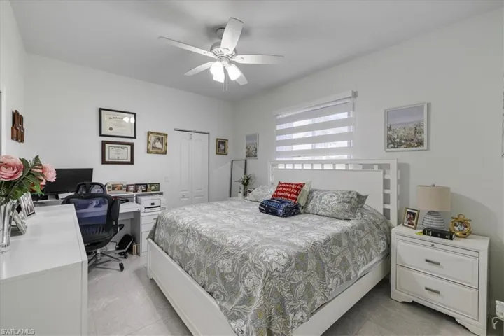 Bedroom with a closet, an office area, and ceiling fan