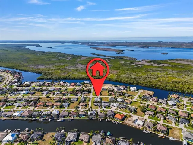 Aerial view of property's location with a large body of water and nearby suburban area