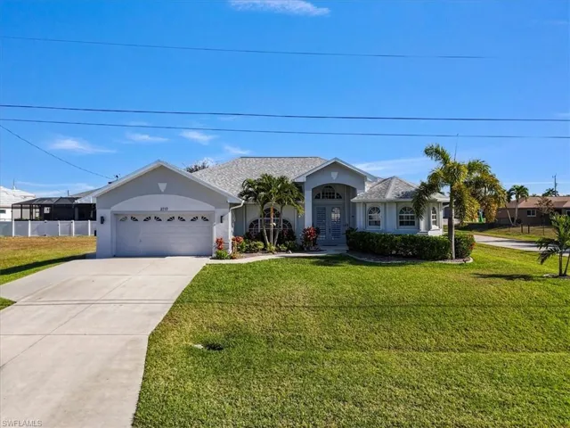 Ranch-style home with stucco siding, a front yard, driveway, and a garage