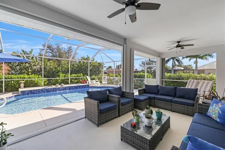 View of patio / terrace with a ceiling fan, glass enclosure, an outdoor pool, a sunroom, and an outdoor living space