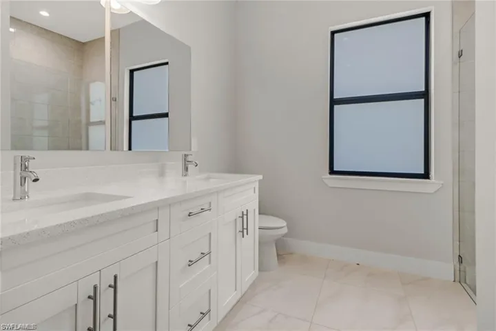Bathroom with walk in shower, vanity, and toilet