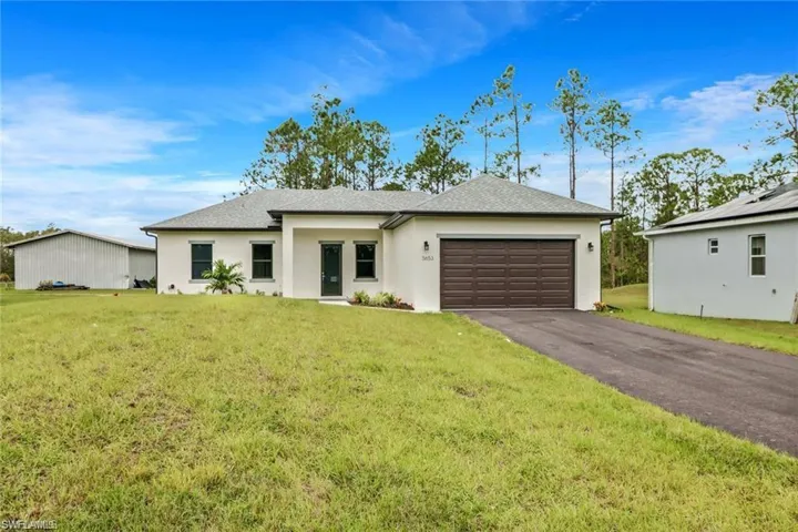 Single story home with a front yard and a garage