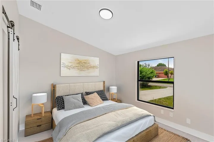 Virtually Staged -Bedroom with a barn door, lofted ceiling, and a closet
