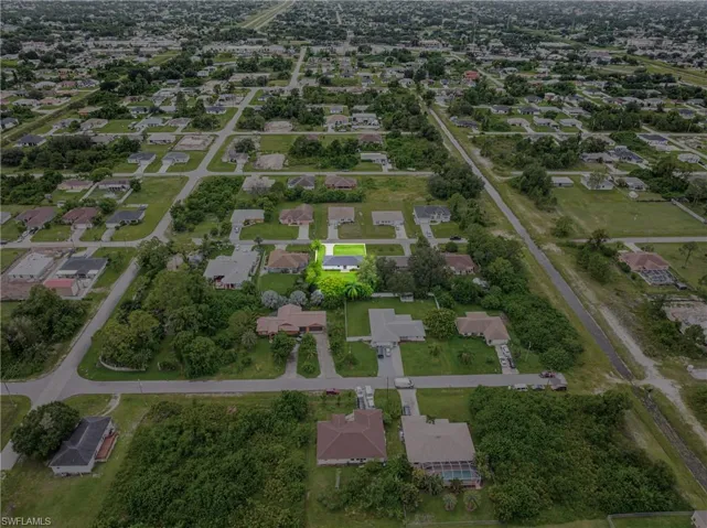 Aerial view of property and surrounding area featuring nearby suburban area