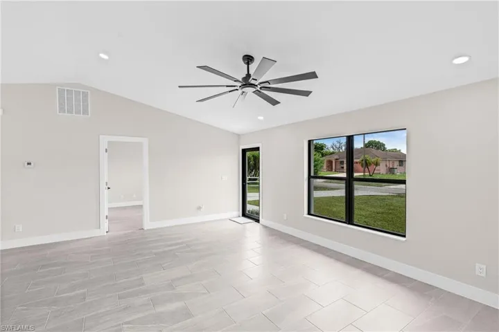 Living room featuring lofted ceiling, recessed lighting, and ceiling fan