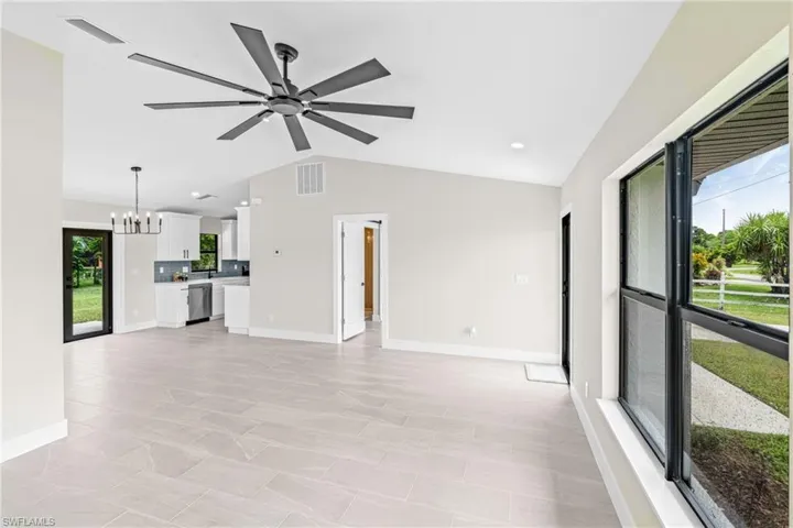 Unfurnished living room featuring a chandelier, vaulted ceiling, recessed lighting, and ceiling fan