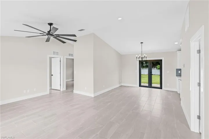 Unfurnished living room with vaulted ceiling, a chandelier, recessed lighting, and a ceiling fan