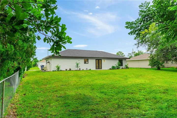 Rear view of property featuring stucco siding and roof with shingles
