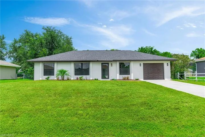 Single story home featuring concrete driveway, an attached garage, roof with shingles, and stucco siding