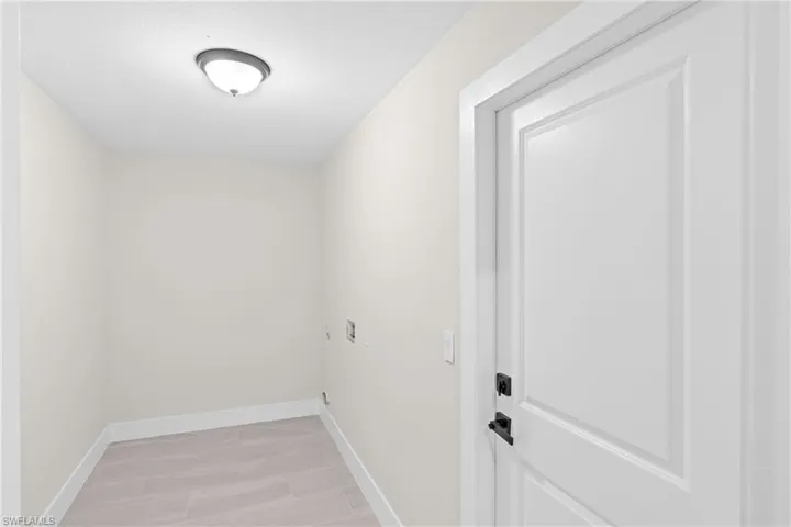 Laundry room featuring baseboards and hookup for an electric dryer