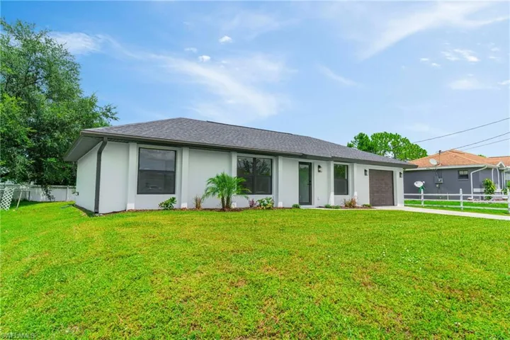 Ranch-style home featuring a garage, driveway, stucco siding, and a shingled roof