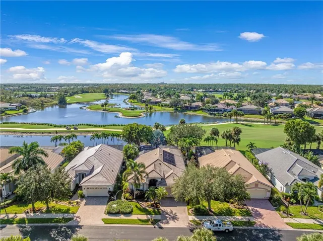 Aerial perspective of suburban area with a golf club and a large body of water