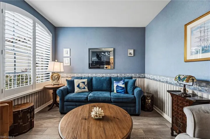 The office/den features a convenient fold-out sofa and elegant French doors for added privacy, while abundant natural light fills the space, creating a bright and inviting atmosphere.