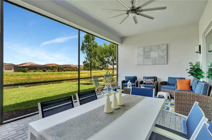 Sunroom featuring ceiling fan, screened enclosure, storm smart automated shades