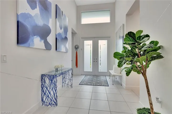 Tiled entryway with a high ceiling and french doors