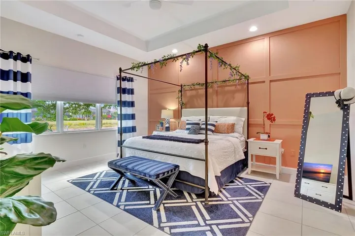 Master Bedroom with tile flooring, ceiling fan, and a raised ceiling. Two large walk in custom built closets.