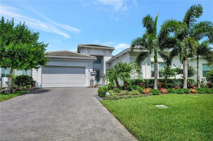 View of front of home with a garage and a front lawn
